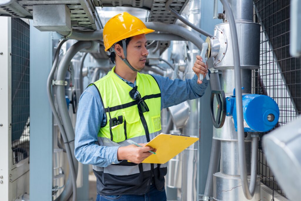 An engineer checks the status of a large AHU air conditioner control valve.