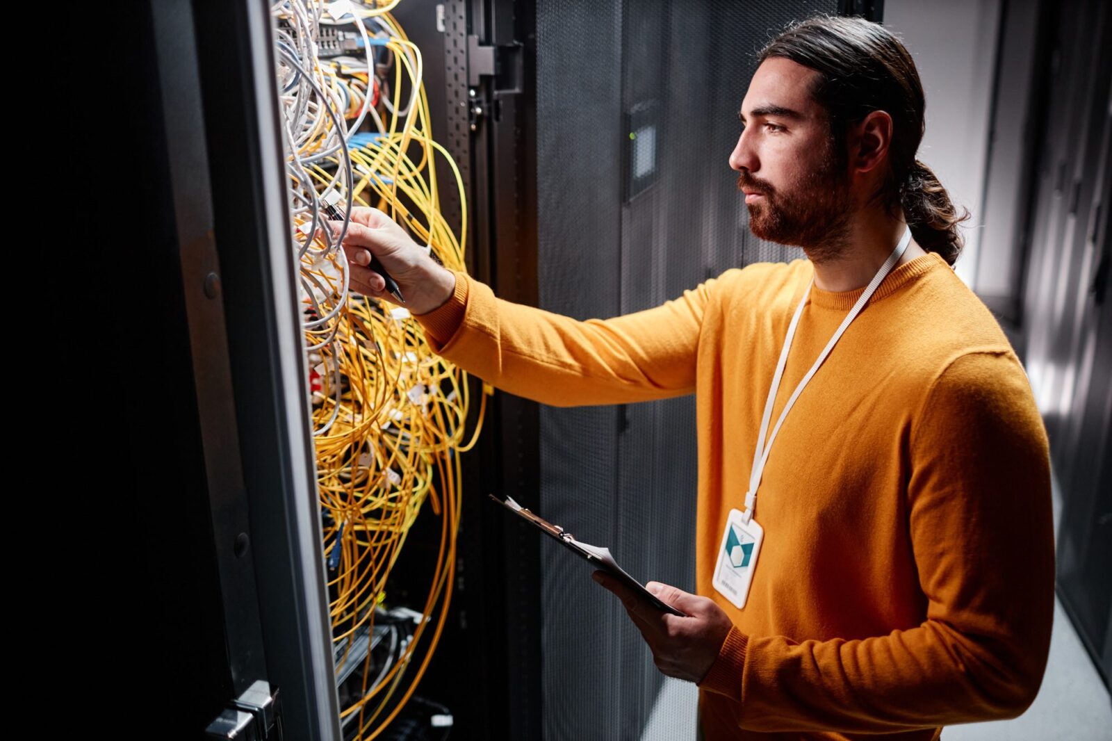 Bearded technician working with server network and connecting cables